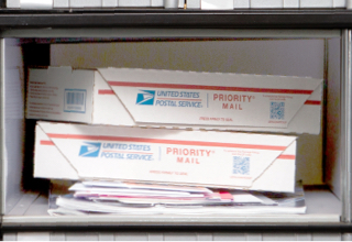 Image of the Medium PO Box, Size 3, with small packages stacked on top of magazines and large envelopes.